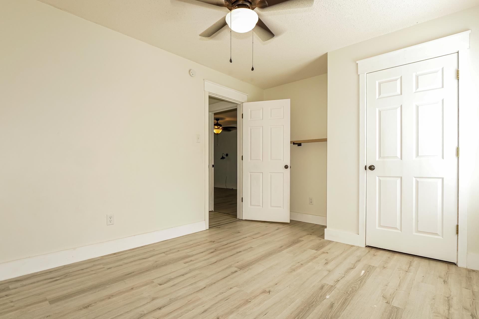 188 David Reed Drive Munford, TN 38058 - Photo 13 of 20 Light wood-finish flooring extending throughout, ceiling fan with integrated lighting, recessed closet with wood shelving, and a panel door with dark hardware