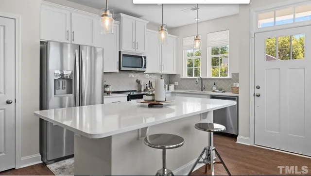a kitchen with stainless steel appliances granite countertop a sink a stove and a refrigerator