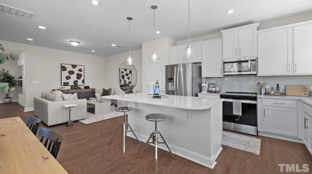 a large kitchen with kitchen island a white cabinets and refrigerator