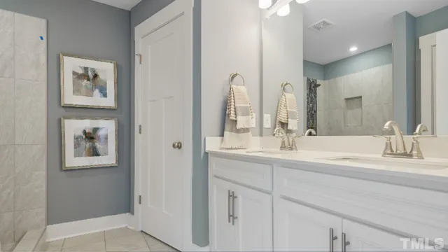 a bathroom with double vanity sinks and a mirror