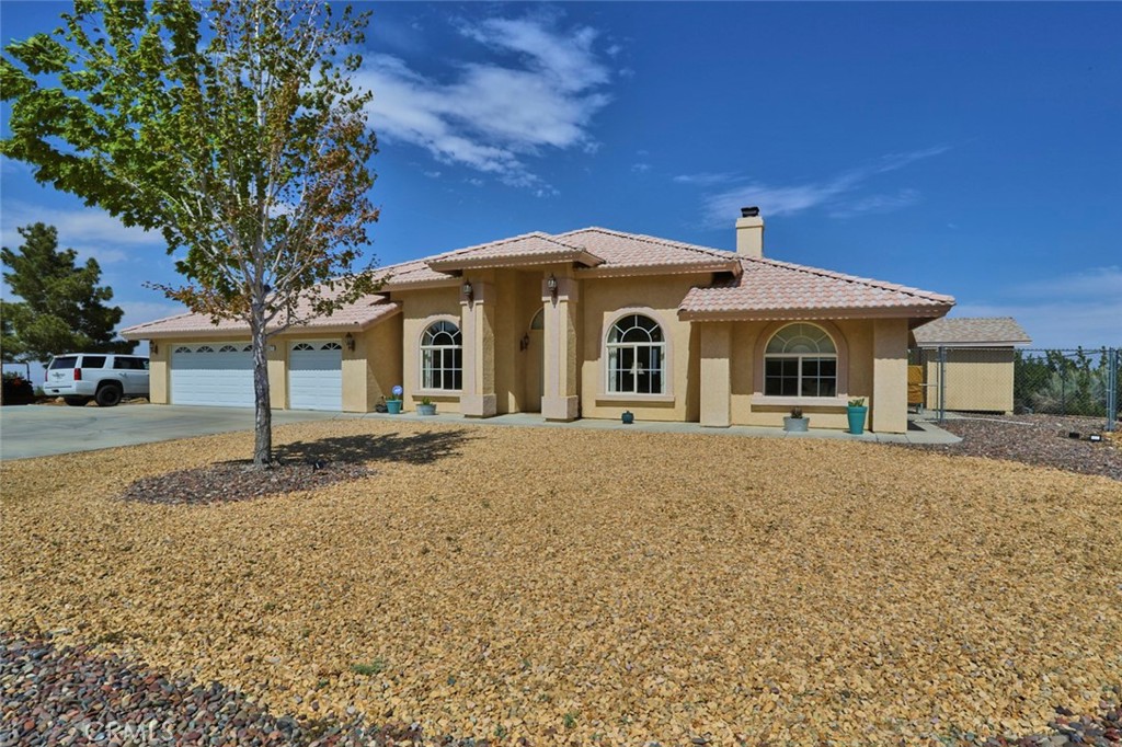 8825 Wintergreen Road Pinon Hills, CA 92372 - Photo 1 of 1 a front view of a house with a garden