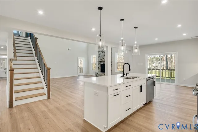 a large kitchen with kitchen island white cabinets and stainless steel appliances