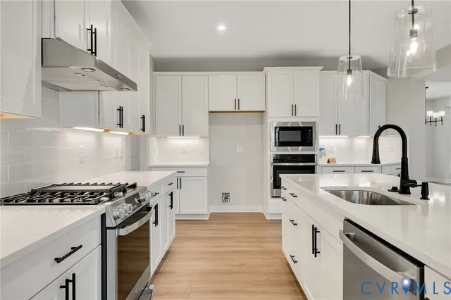 a kitchen with kitchen island stainless steel appliances a sink stove and refrigerator
