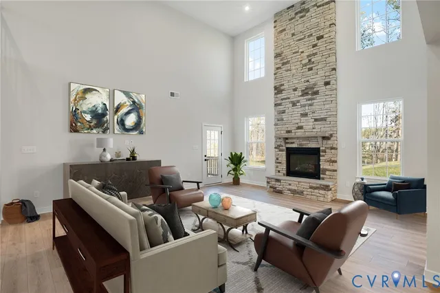 an empty room with wooden floor fireplace and windows
