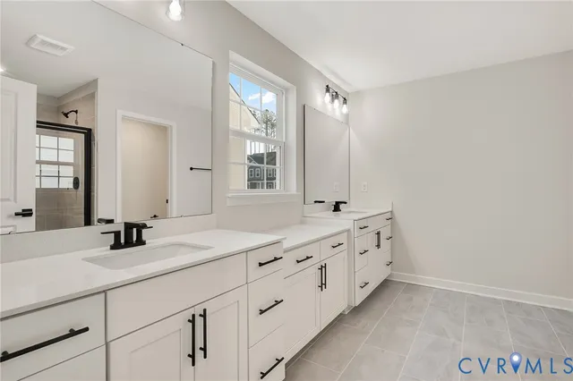 a spacious bathroom with double sink and a mirror