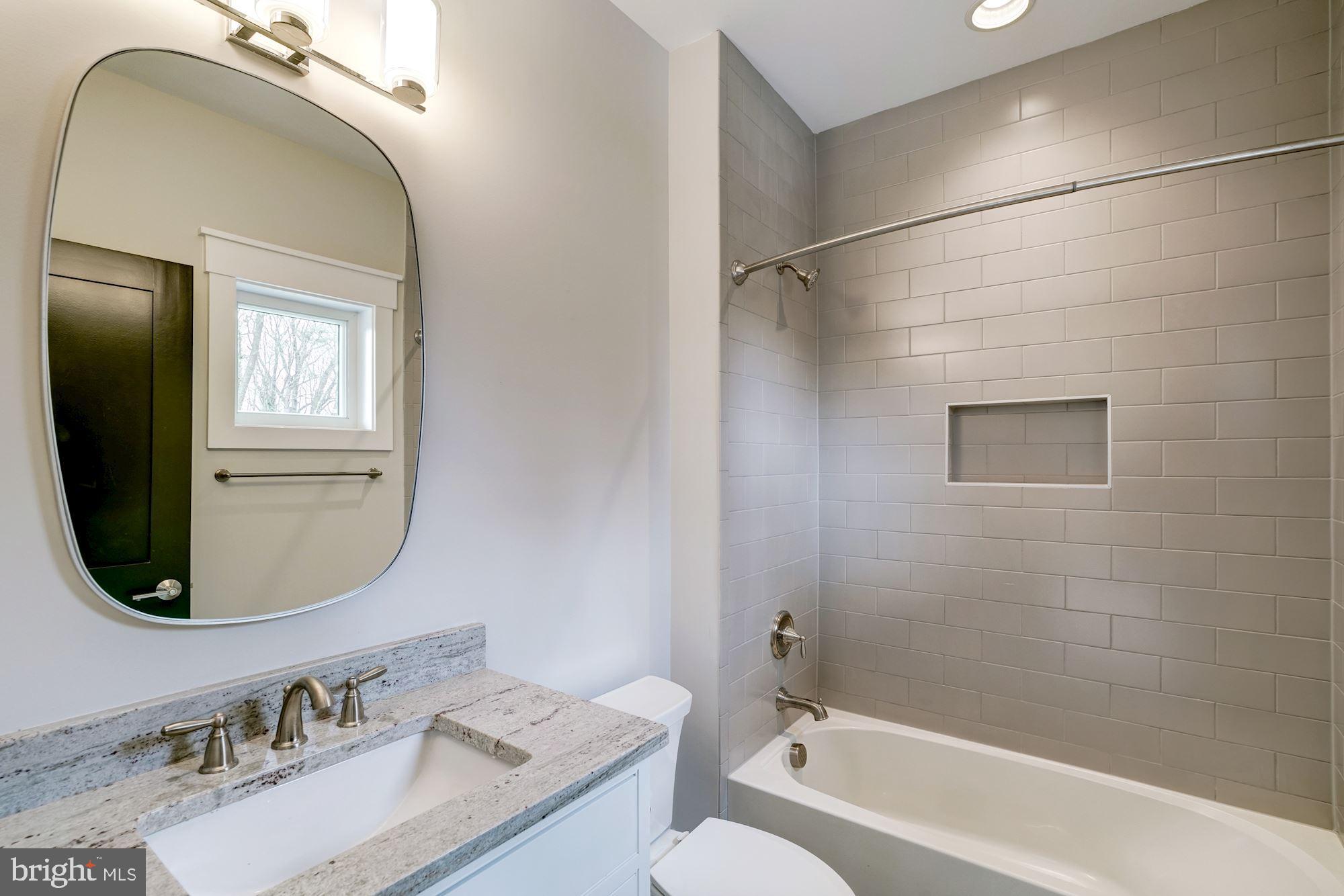 1826 Kirby Road McLean, VA 22101 - Photo 36 of 56 a bathroom with a granite countertop sink a mirror and shower