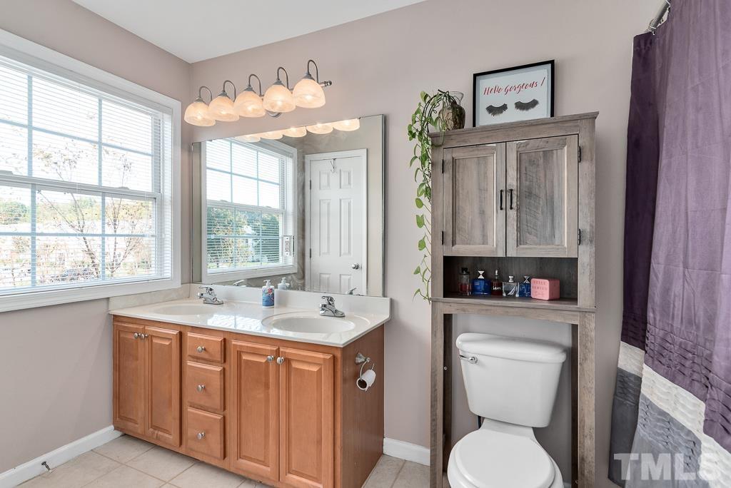 2041 Rivergate Road, Unit 104 Raleigh, NC 27614 - Photo 14 of 21 a spacious bathroom with a toilet sink and mirror