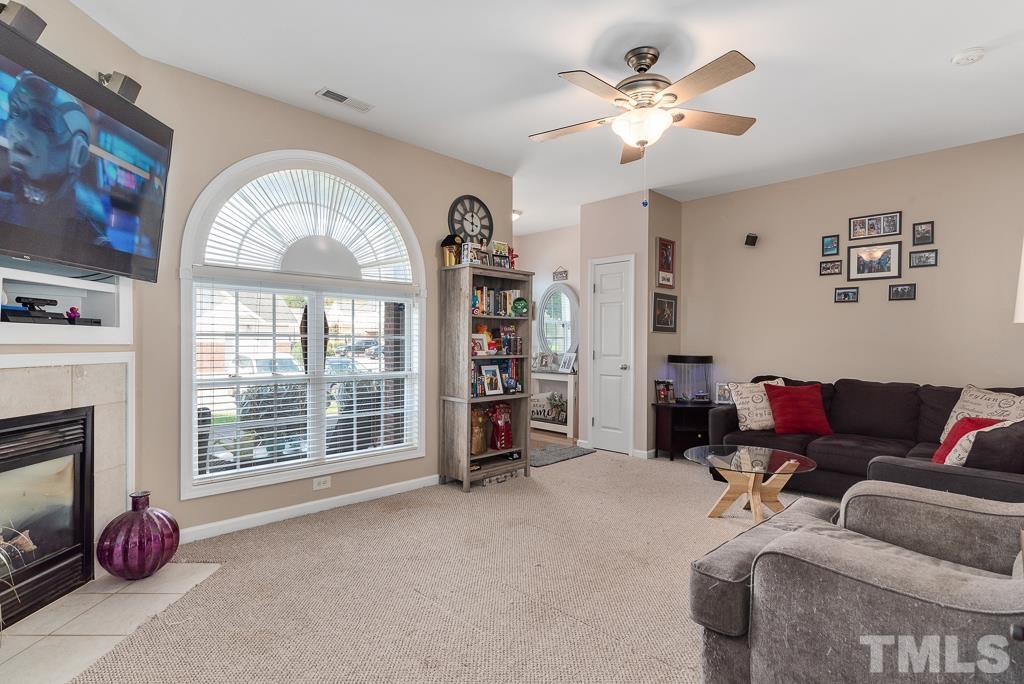 2041 Rivergate Road, Unit 104 Raleigh, NC 27614 - Photo 3 of 21 a living room with furniture a fireplace and a large window