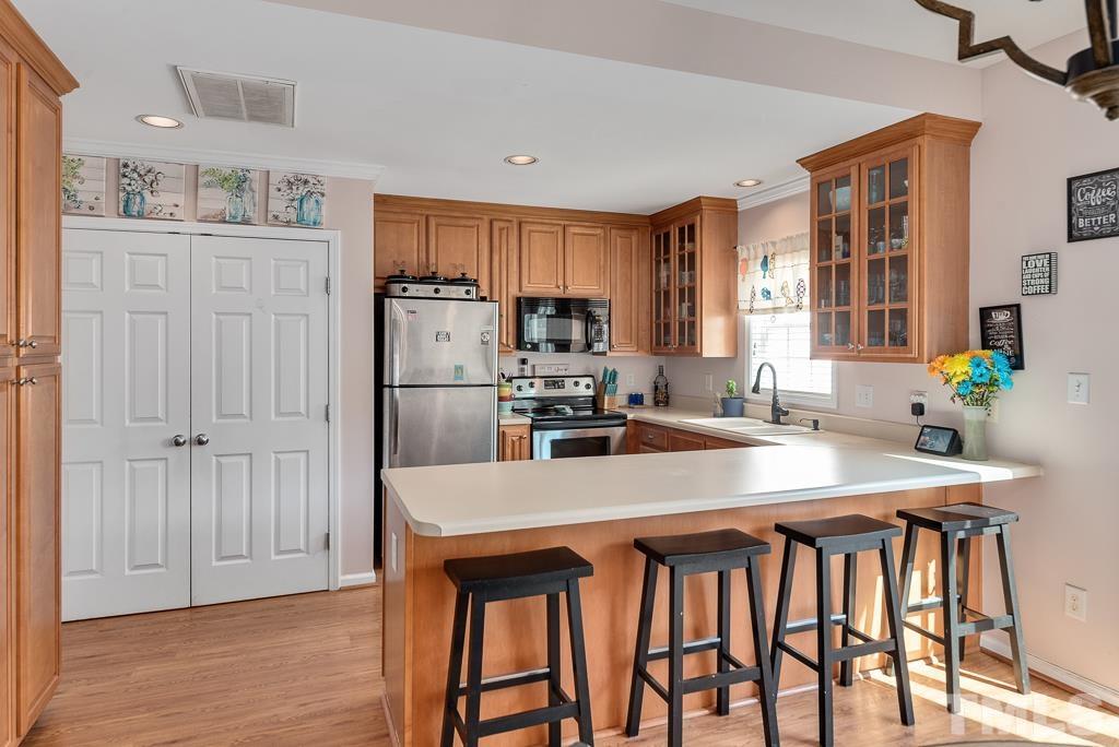 2041 Rivergate Road, Unit 104 Raleigh, NC 27614 - Photo 8 of 21 a kitchen with a table chairs refrigerator and cabinets