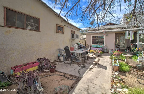 a view of a patio with table and chairs potted plants and large tree