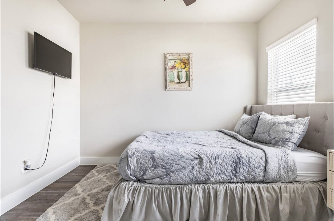 1740 Cove Crescent Houston, TX 77055 - Photo 16 of 44 a bedroom with a bed and a flat screen tv