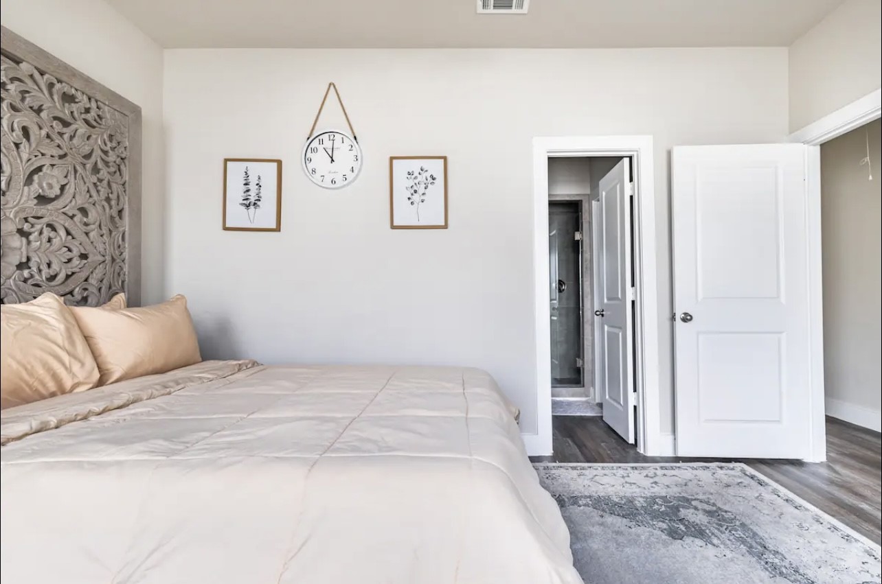 1740 Cove Crescent Houston, TX 77055 - Photo 19 of 44 a bedroom with a large bed and a chandelier