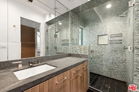a bathroom with a sink and mirror with toilet
