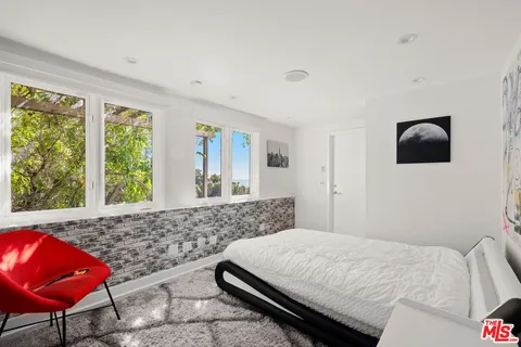 a living room with furniture a bookshelf and a window