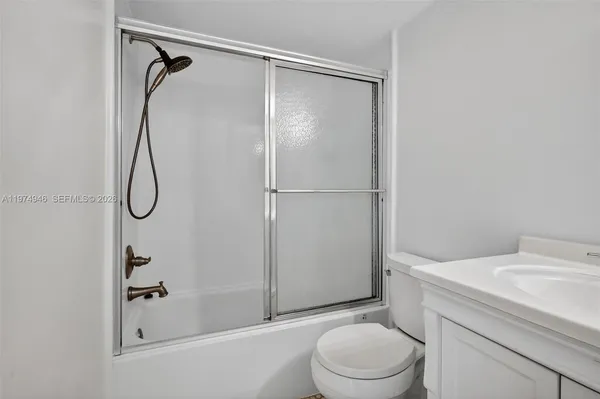 a bathroom with a granite countertop toilet and a shower