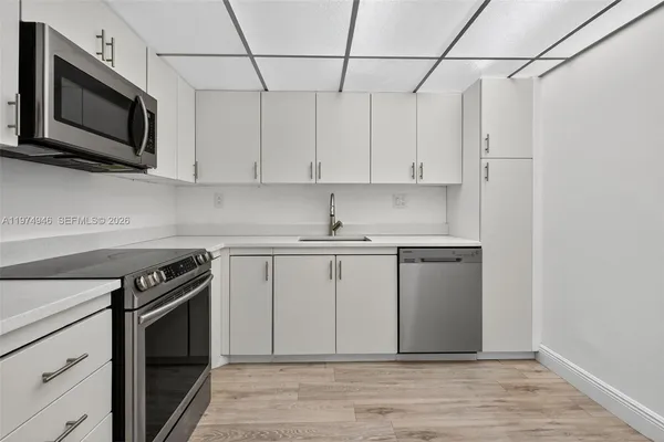 a kitchen with stainless steel appliances granite countertop a sink a stove a microwave and cabinets