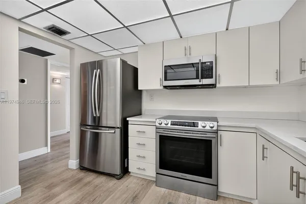 a kitchen with stainless steel appliances granite countertop a refrigerator and a stove top oven