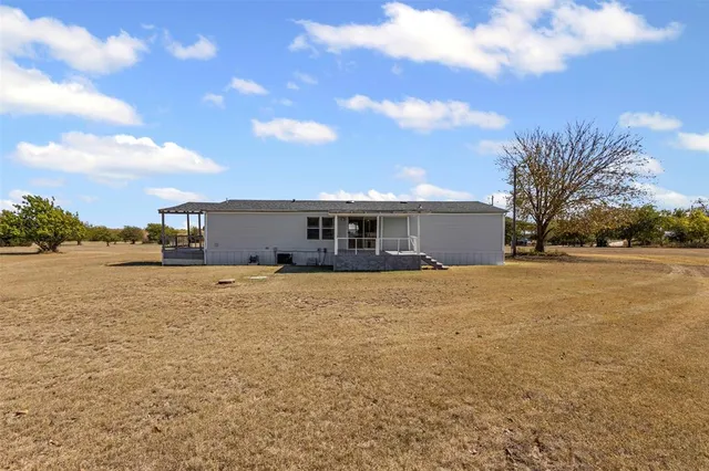 a front view of house with yard and car parked