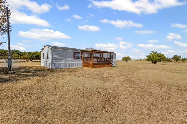 a view of a house with backyard and trees