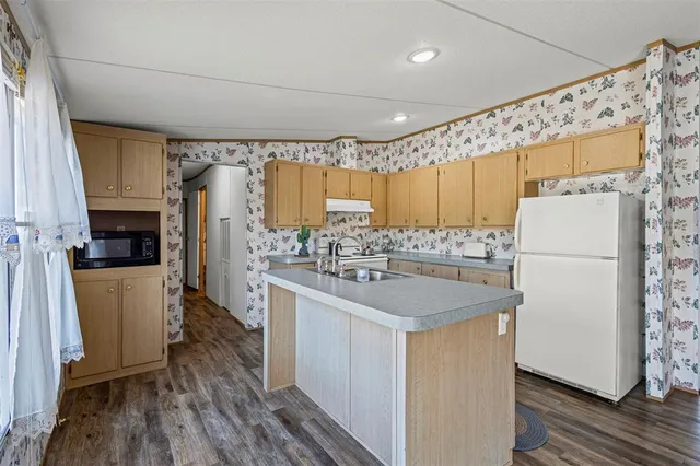 a kitchen with a sink a refrigerator and a stove top oven