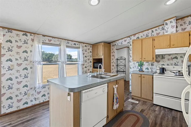 a kitchen with sink cabinets and wooden floor