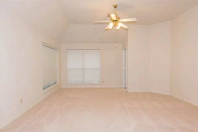 an empty room with chandelier fan