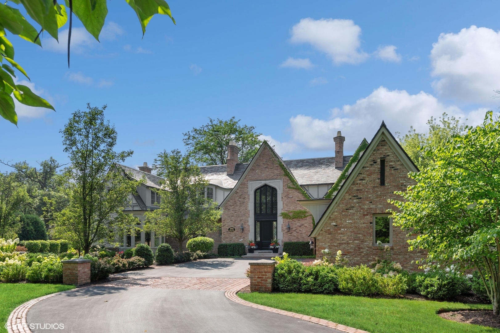 a front view of a house with a yard and potted plants