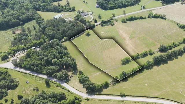 an aerial view of a house with a yard and pool
