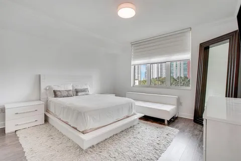 a bedroom with a bed and a large window