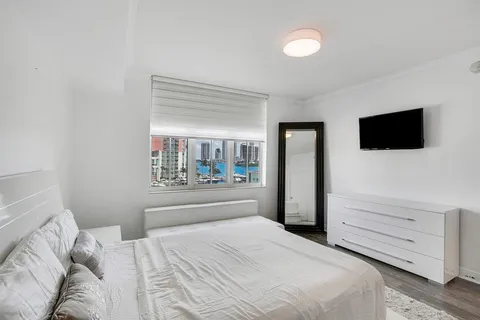 a bedroom with a bed and a flat screen tv