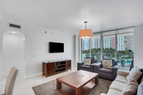 a living room with furniture a flat screen tv and a fireplace