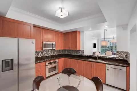 a kitchen with granite countertop a sink stainless steel appliances and cabinets