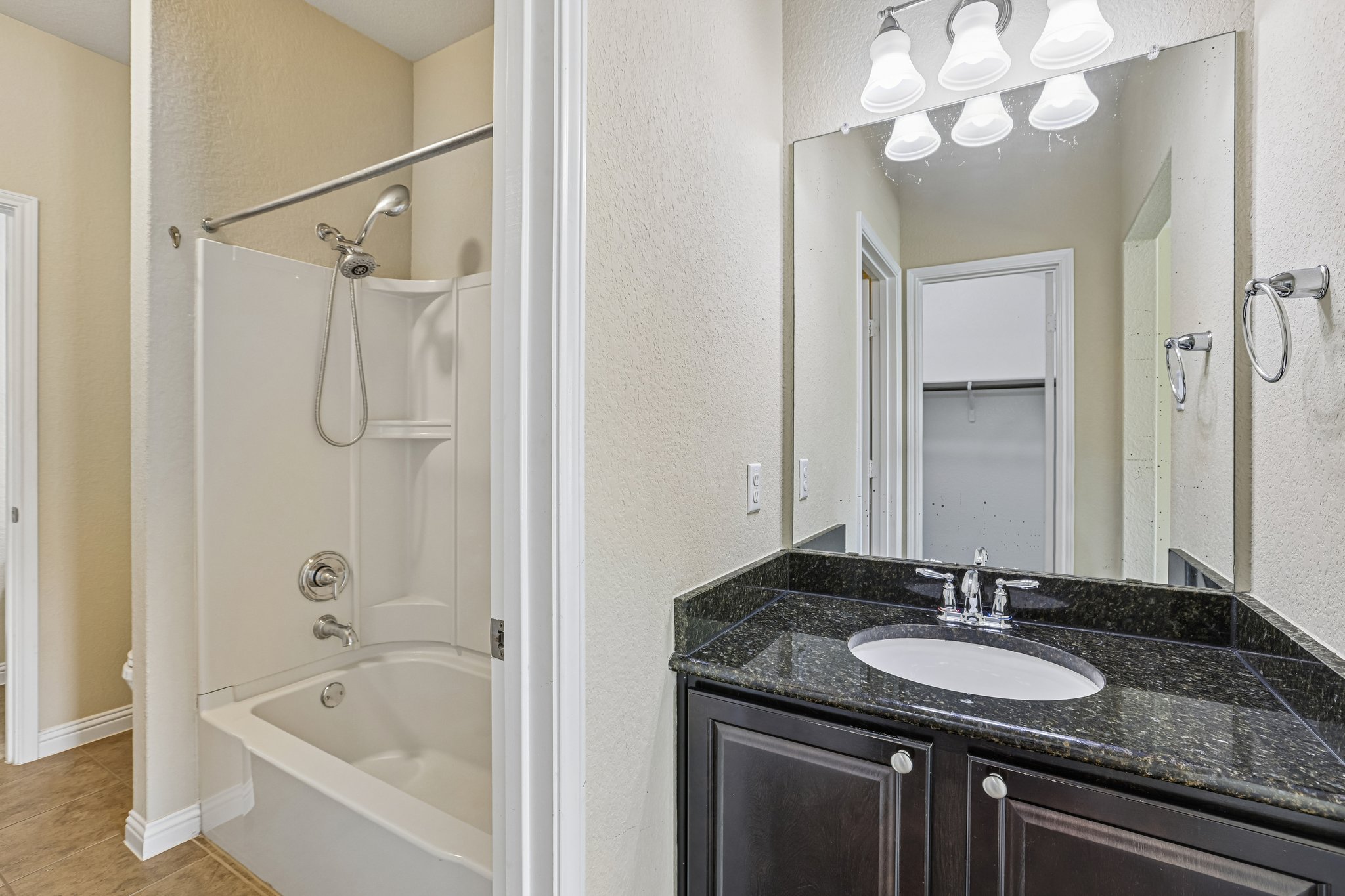 1924 Granite Springs Road Leander, TX 78641 - Photo 29 of 36 Jack and Jill bathroom connecting Guest bedrooms #3 and #4. Granite counters complement the classic cabinetry in this functional bathing space, complete with a shower-tub combination.