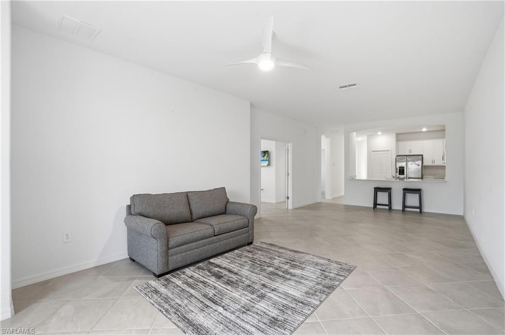 2215 Dragonfruit Way Naples, FL 34120 - Photo 8 of 38 a living room with furniture and a dining table with kitchen view
