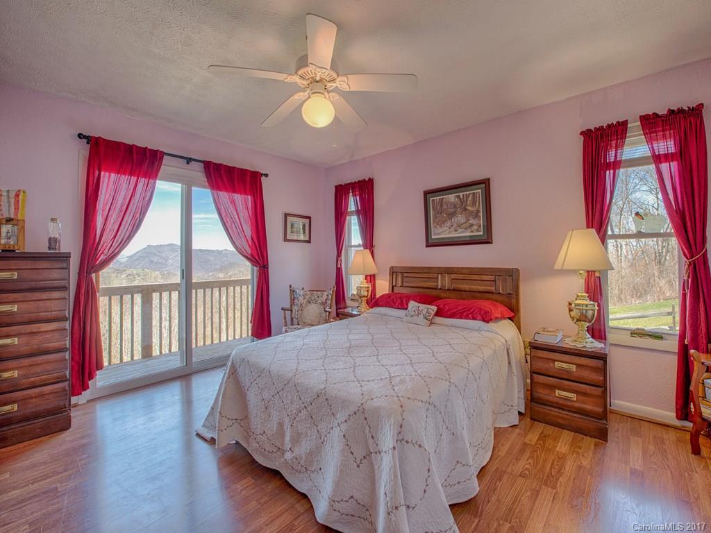 450 Windswept Ridge Road Leicester, NC 28748 - Photo 12 of 18 a bedroom with a bed and a chandelier