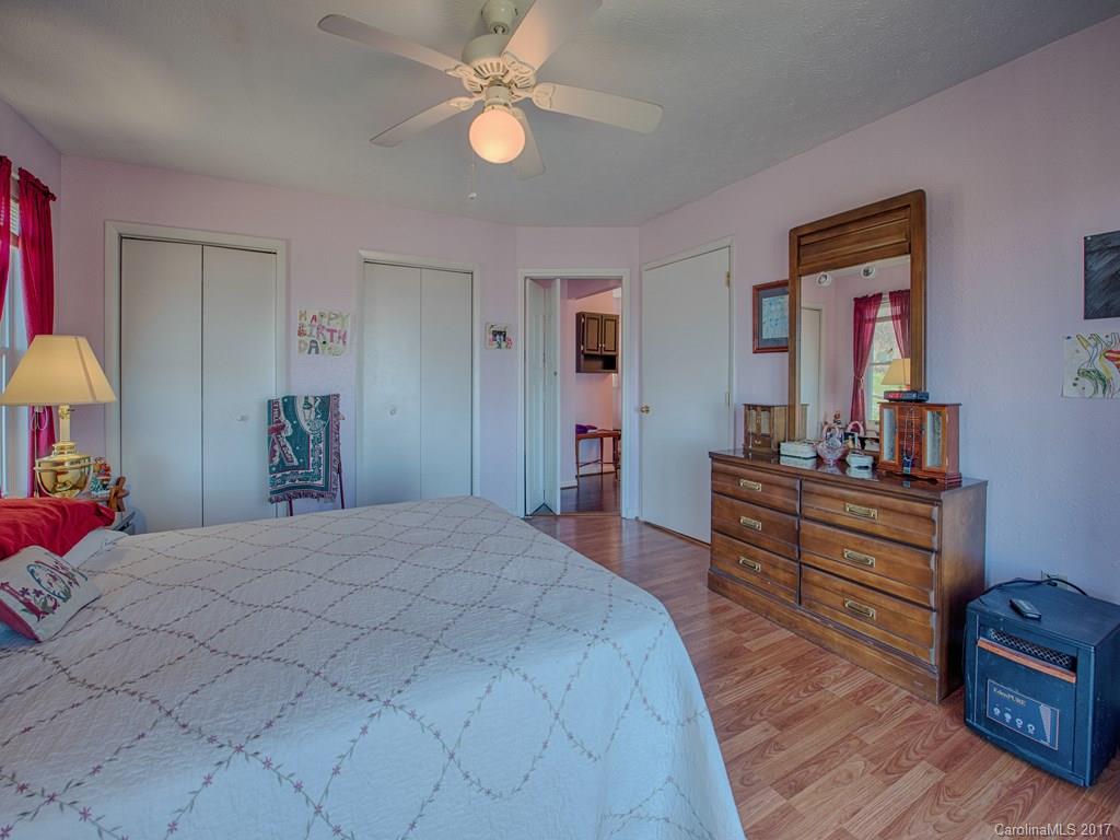 450 Windswept Ridge Road Leicester, NC 28748 - Photo 13 of 18 a bedroom with a bed and a chandelier