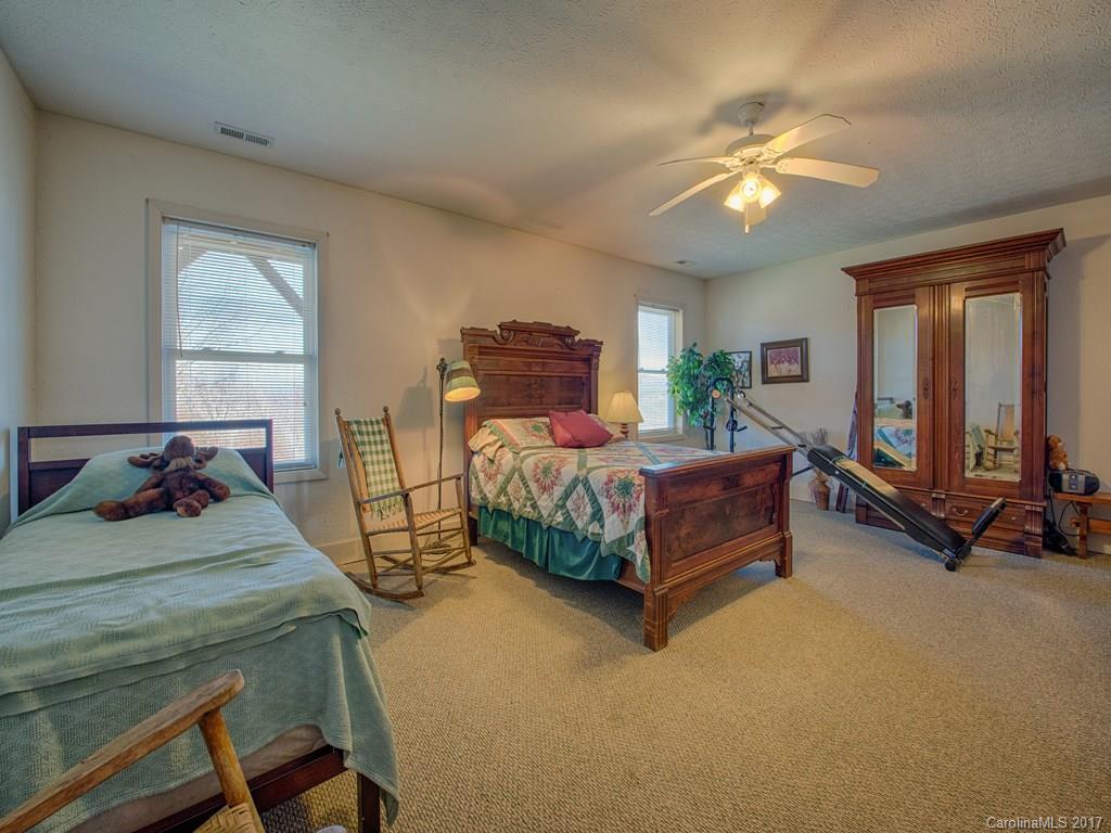 450 Windswept Ridge Road Leicester, NC 28748 - Photo 15 of 18 a bedroom with a bed a chandelier and dresser