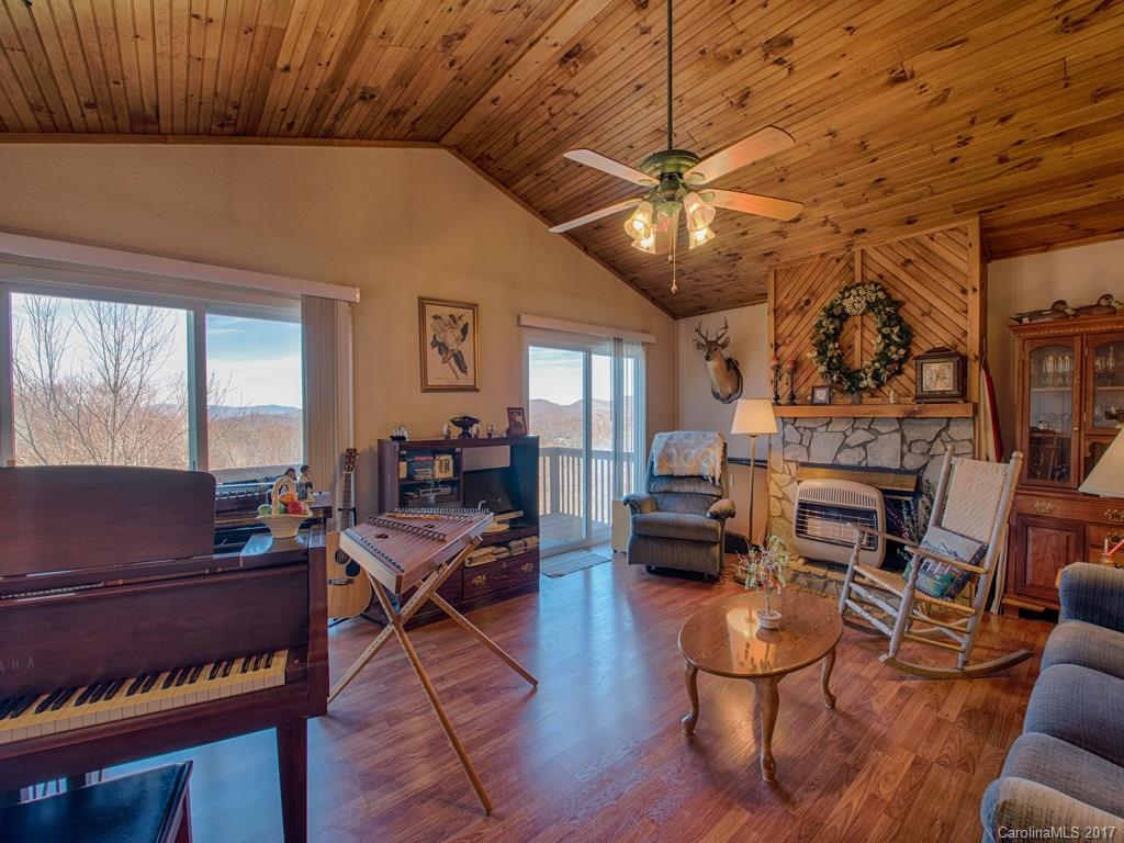 450 Windswept Ridge Road Leicester, NC 28748 - Photo 7 of 18 a living room with furniture a fireplace and a flat screen tv