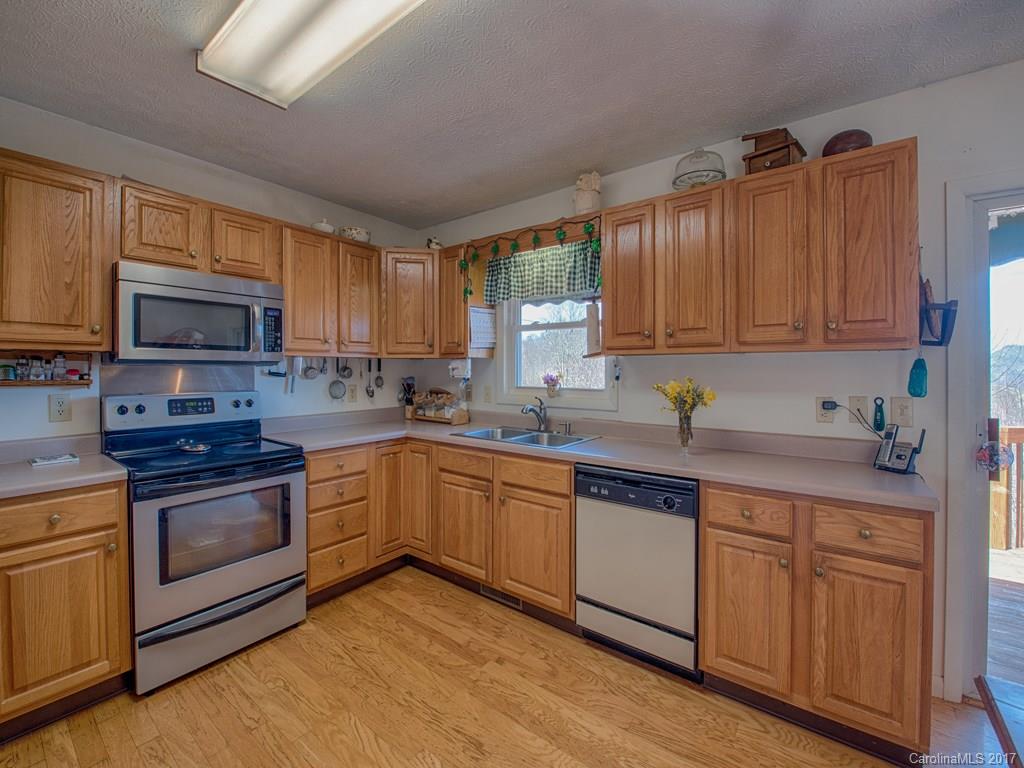450 Windswept Ridge Road Leicester, NC 28748 - Photo 10 of 18 a kitchen with sink a microwave and cabinets