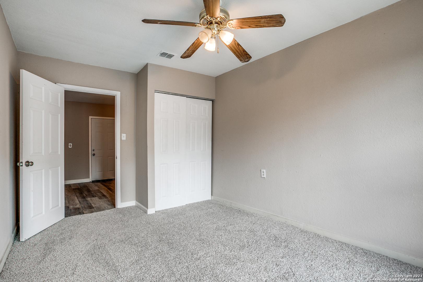 a view of a room with a chandelier fan and closet