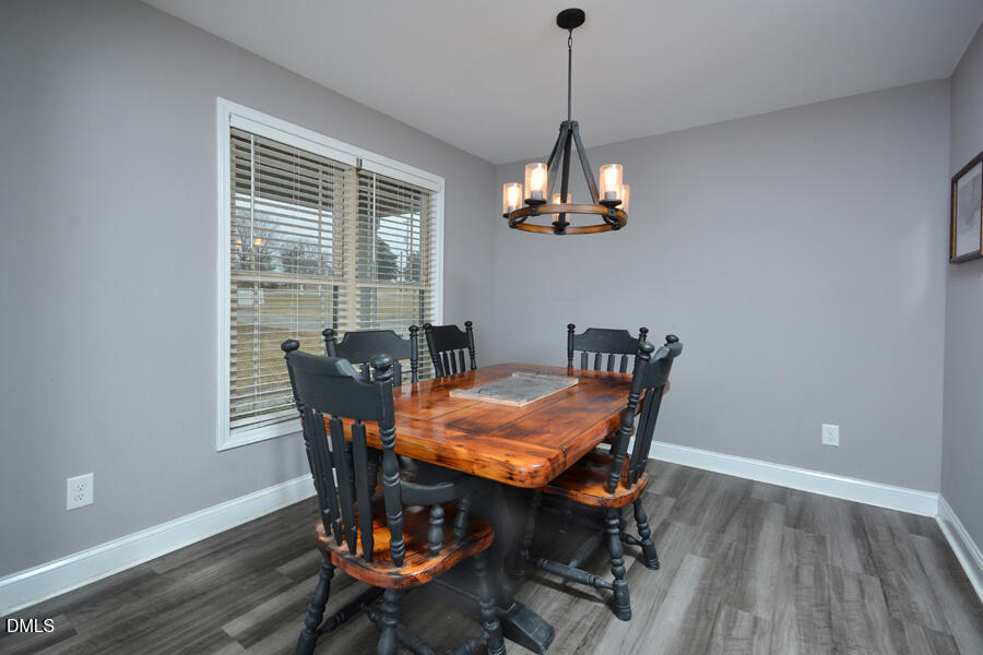 3082 East Thollie Green Road Stem, NC 27581 - Photo 19 of 45 a view of a dining room with furniture wooden floor and chandelier
