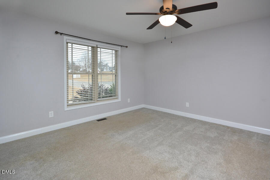 3082 East Thollie Green Road Stem, NC 27581 - Photo 22 of 45 an empty room with a window and a fan