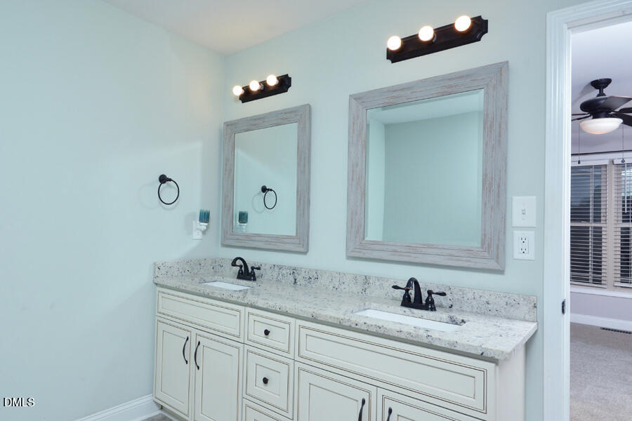 3082 East Thollie Green Road Stem, NC 27581 - Photo 27 of 45 a bathroom with a granite countertop sink and a mirror