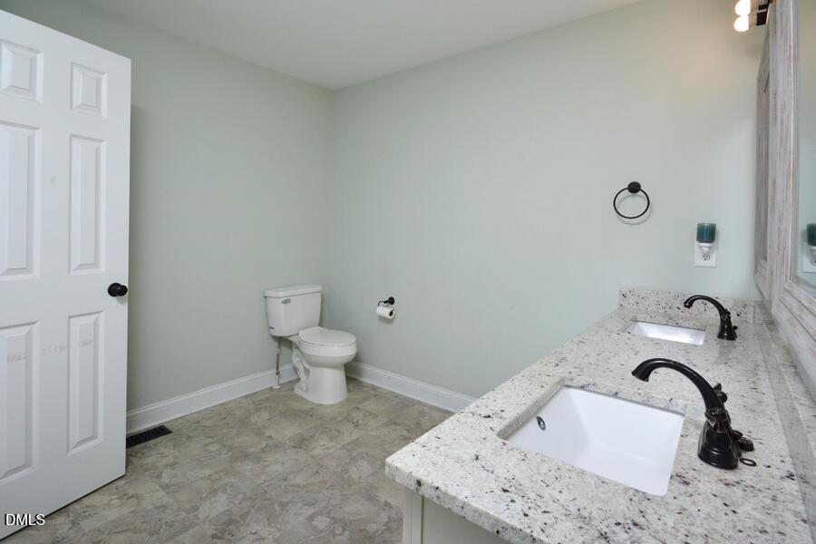3082 East Thollie Green Road Stem, NC 27581 - Photo 29 of 45 a bathroom with a sink and a toilet