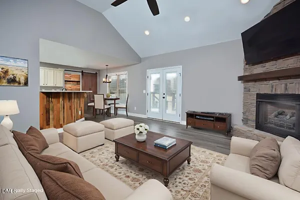 a view of an empty room with wooden floor fireplace and a window