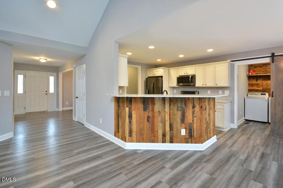 3082 East Thollie Green Road Stem, NC 27581 - Photo 10 of 45 a view of kitchen with wooden floor and window