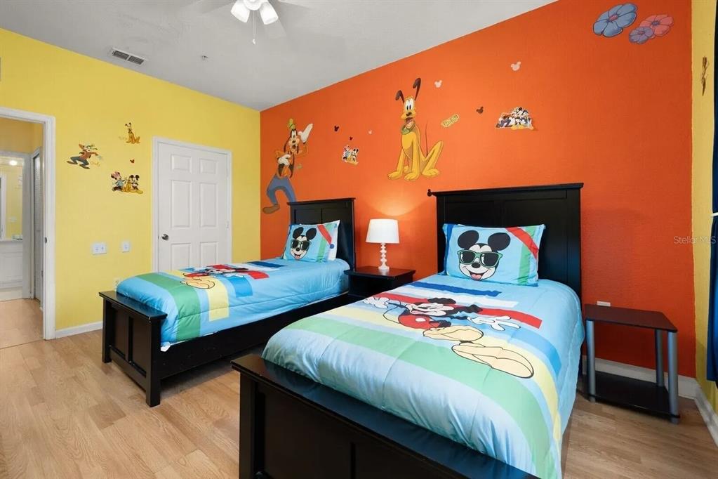 7664 Comrow Street, Unit 302 Kissimmee, FL 34747 - Photo 11 of 19 a bedroom with two beds and a chandelier