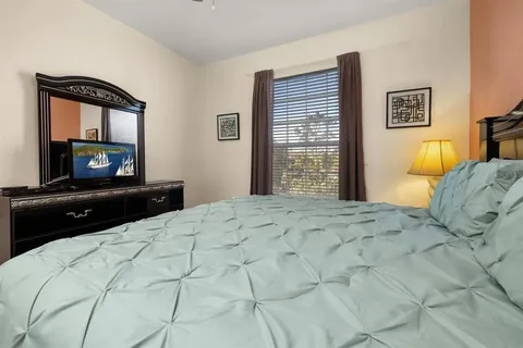a bedroom with a bed and a television