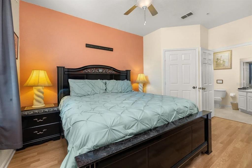 7664 Comrow Street, Unit 302 Kissimmee, FL 34747 - Photo 16 of 19 a bedroom with a bed and wooden floor