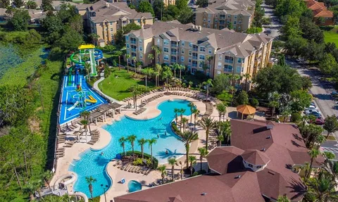 an aerial view of a house with a yard and outdoor seating